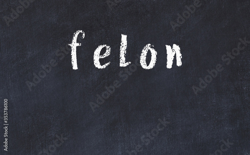 College chalk desk with the word felon written on in photo