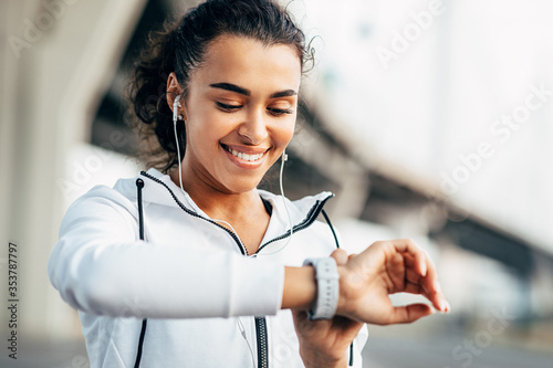 Foto Smiling woman checking her physical activity on smartwatch