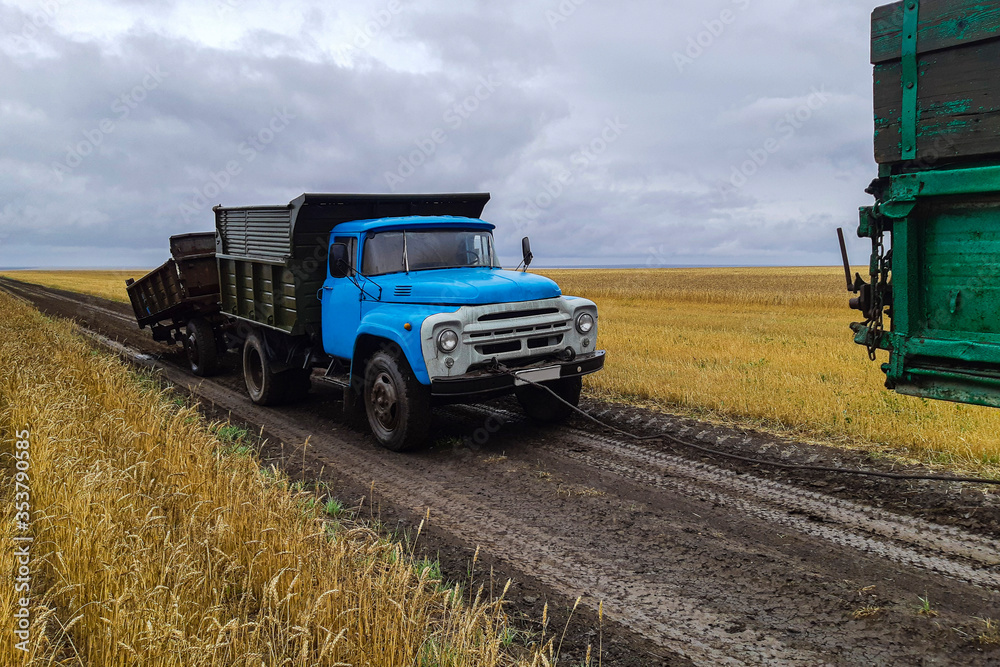 a truck with a broken trailer without a wheel broke another truck in the field in tow a truck with a broken trailer without a wheel broke another truck in the field in tow