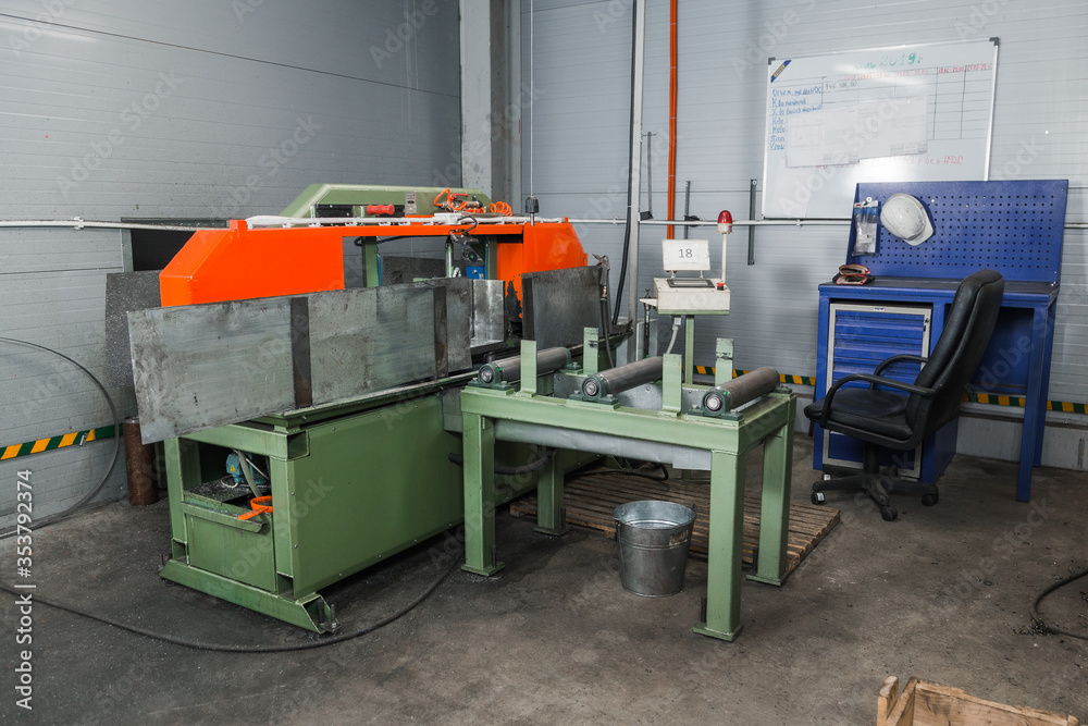 Band saw for industrial high speed cutting metal pipe and using coolant. Hack sawing machine working to cutting metal. Precision equipment on manufacture factory line of heavy industry indoors Band saw for industrial high speed cutting metal pipe and using coolant. Hack sawing machine working to cutting metal. Precision equipment on manufacture factory line of heavy industry indoors