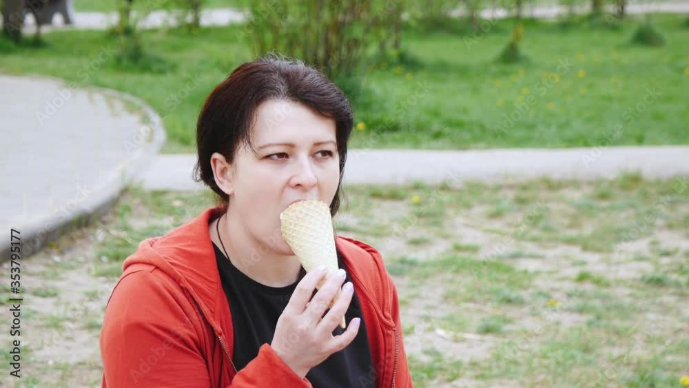 Woman eating a waffle cone with ice cream in the Park. Woman eating a waffle cone with ice cream in the Park.