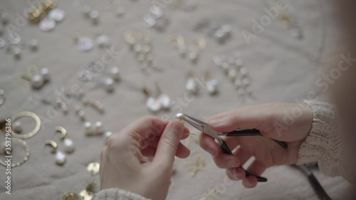 Jewelry designer working with tools making pearl earrings photo