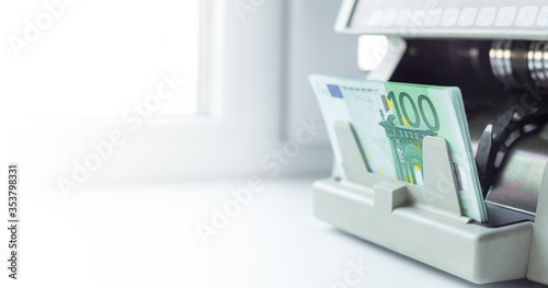 Euro EUR banknotes of 100 on money counter machine. Automatic money counting in the machine photo