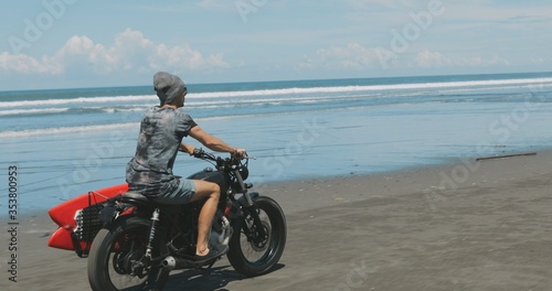 Motorcyclist driving his motorbike on the beach
