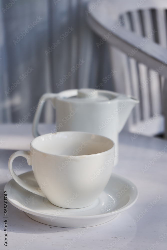 Cup of tea with ceramic tea pot on the white table Cup of tea with ceramic tea pot on the white table