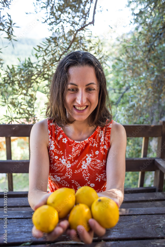 Woman holds freshly picked lemons in her hands Woman holds freshly picked lemons in her hands