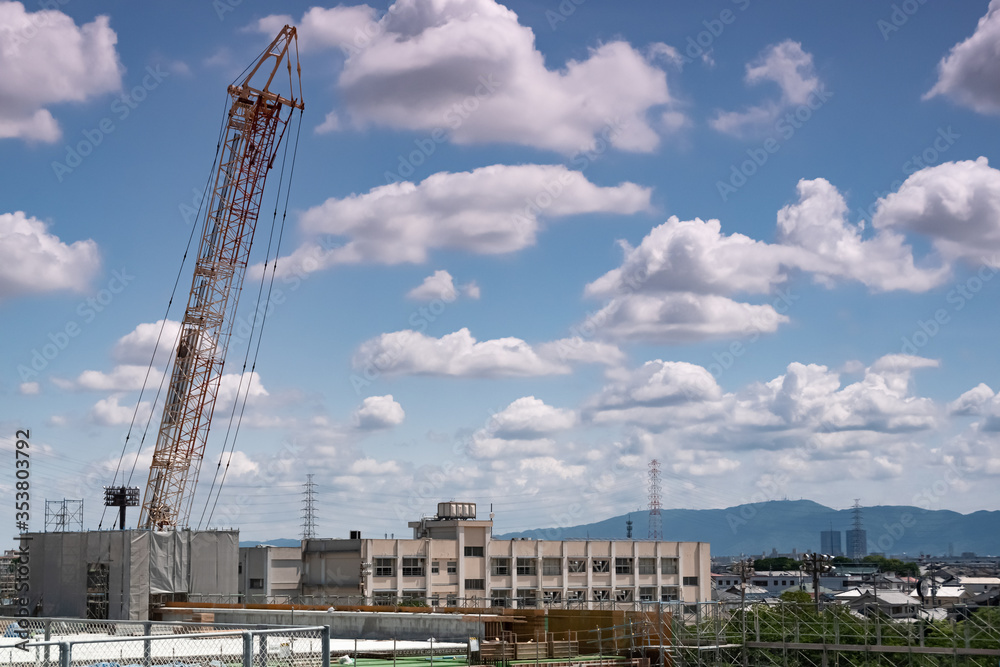 工事現場のクレーンと生駒山