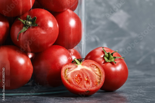 Juicy tomatoes in a glass vase gray background. Fresh, juicy, healthy vegetables. View from above