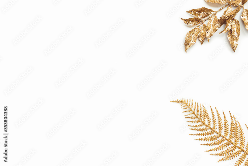 Golden laurel and fern leaves over white background. Copy space.
