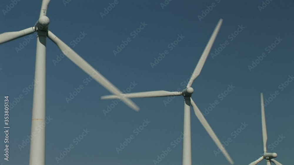 Wind turbines turning in the wind on a farm in England wild flowers UK Wind turbines turning in the wind on a farm in England wild flowers UK