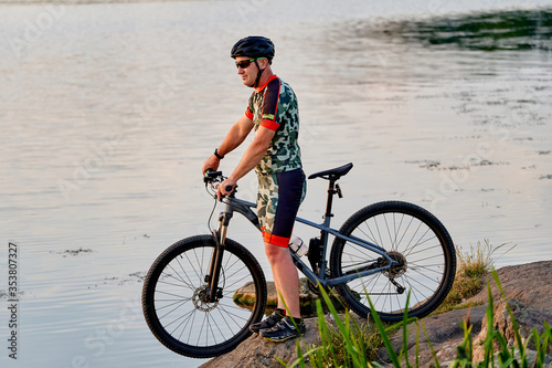 Mountain biker looking at view and traveling on bike. Lake landscape.