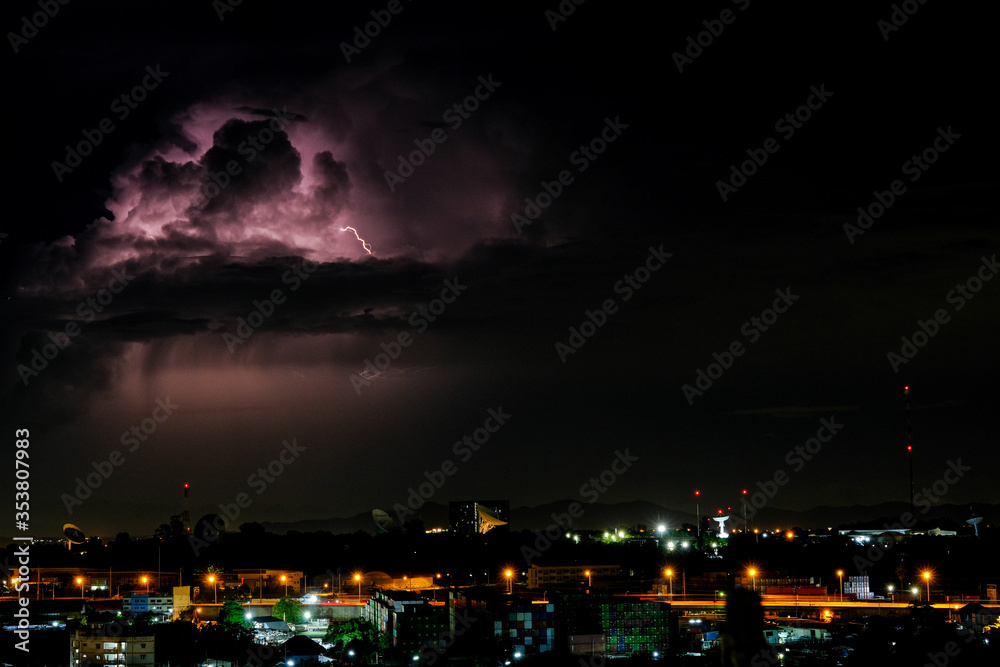 Cloudy with Bright lightning bolt strikes in the rural landscape of small city and satellite station