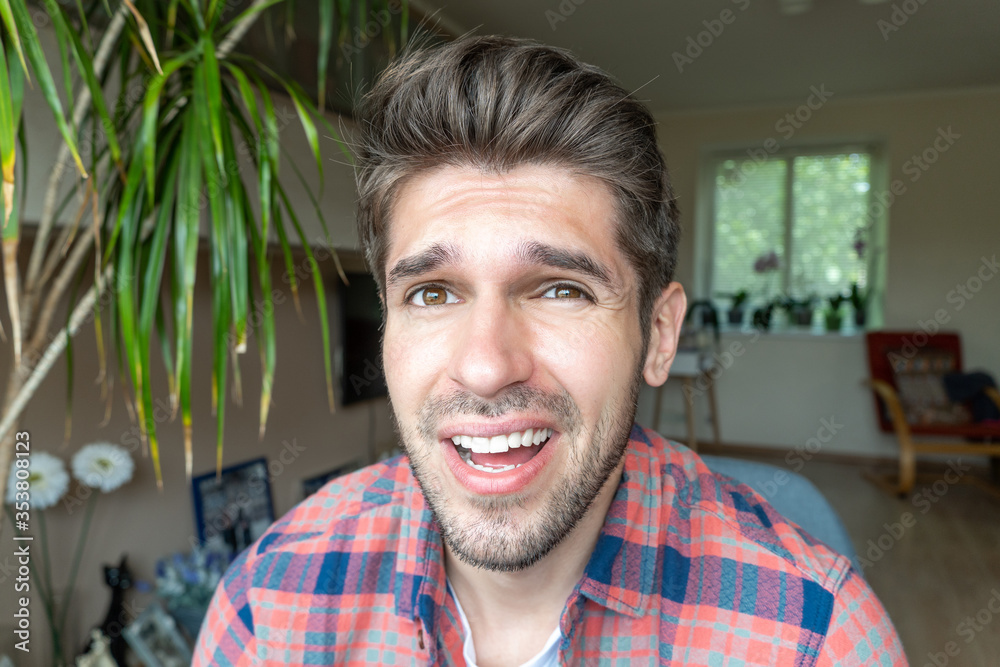 Portrait of a handsome latin guy with a confused expression on his face sitting in a shirt 
