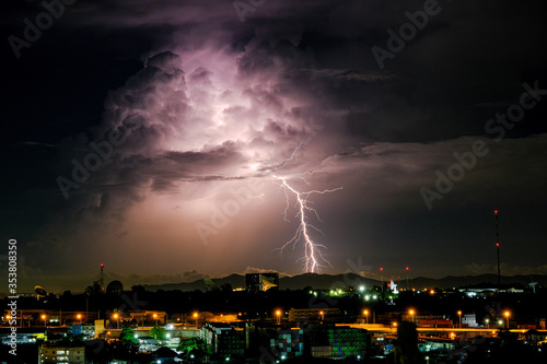 Cloudy with Bright lightning bolt strikes in the rural landscape of small city and satellite station