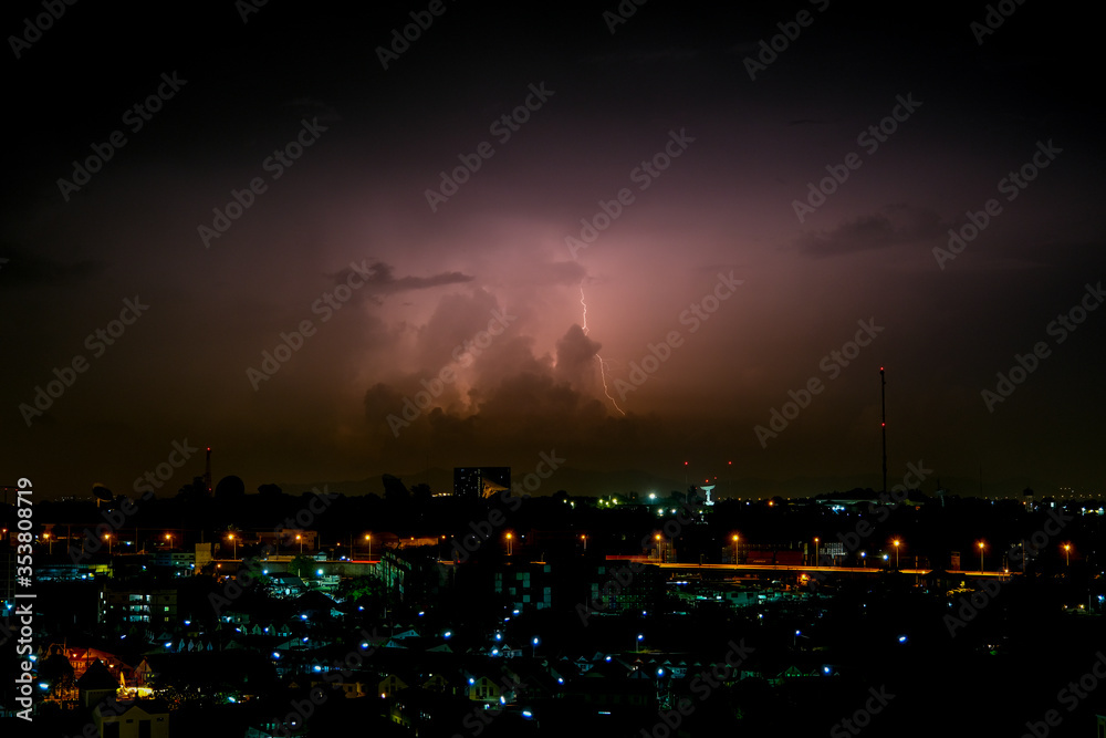 Cloudy with Bright lightning bolt strikes in the rural landscape of small city and satellite station