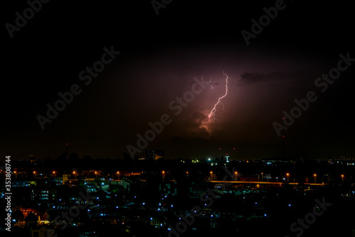 Cloudy with Bright lightning bolt strikes in the rural landscape of small city and satellite station © Peerapixs