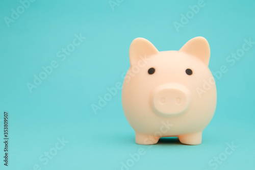 Pink piggy bank on blue background space for text. Savings concept.