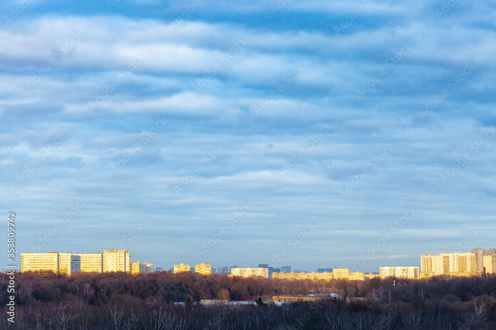 dark blue clouds over urban park in Moscow city at spring sunset