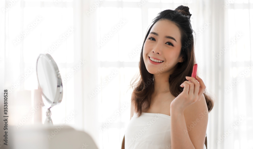 Smiling beautiful woman fresh healthy skin looking on mirror and enjoying applying lips with red lipstick at home.facial beauty and cosmetic concept Smiling beautiful woman fresh healthy skin looking on mirror and enjoying applying lips with red lipstick at home.facial beauty and cosmetic concept