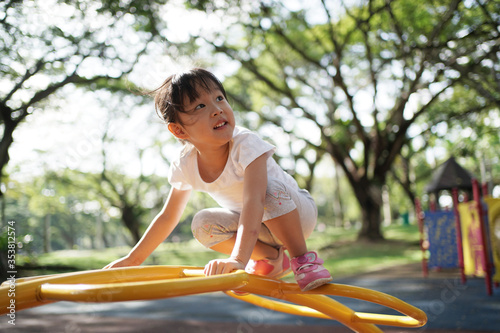 Photography Asian chinese girl managing playground obstacle on her own