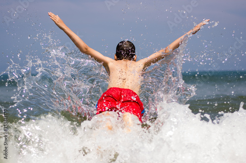 Splash of a kid jumping waves on the sea. © Jorge