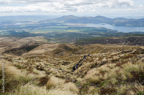 Hikers walking the Tongariro Alphine Crossing on the way down. Tongariro National Park, New Zealand photo