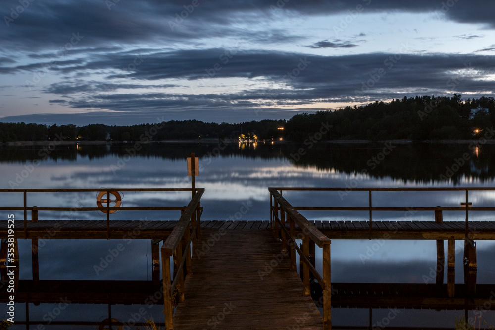 Fototapeta premium Stockholm, Sweden A midsummer midnight sun view over lake Malaren and a dock.