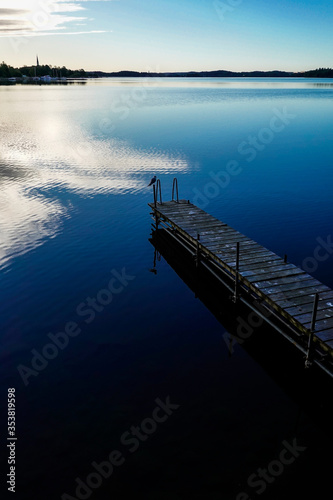 Stockholm, Sweden A small dock on Lake Malaren and the Ekero Church in the background. photo