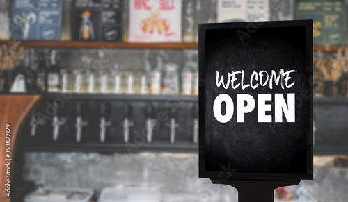 Come in We’re Open’ on cafe waiter standing in front of coffee shop vintage retro sign Open sign at coffee