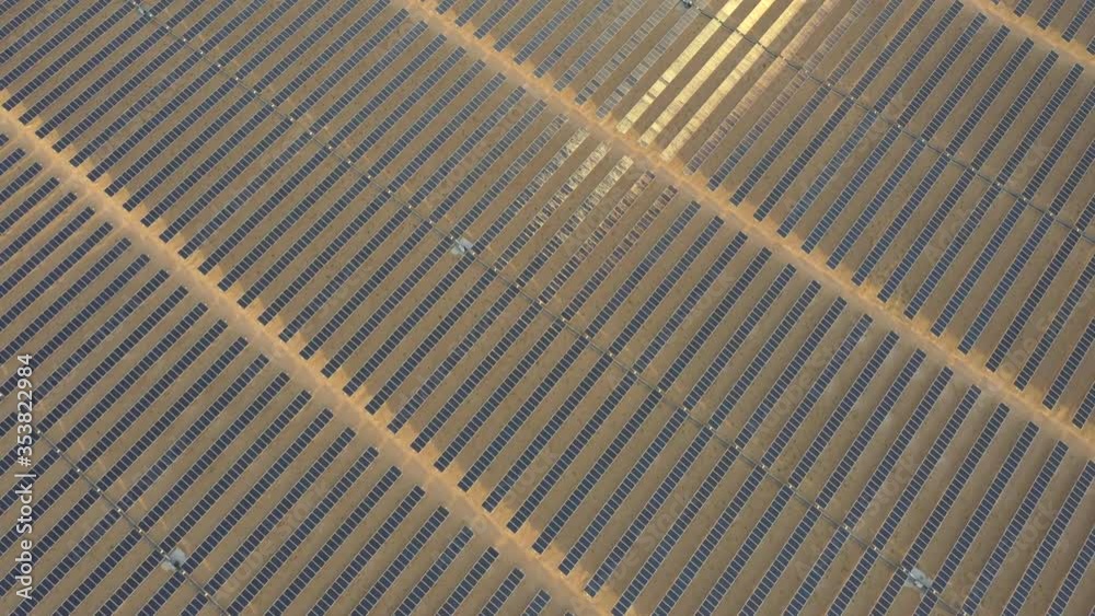 Aerial view from a drone flying diagonally over photovoltaic panels in a desert solar farm. Aerial view from a drone flying diagonally over photovoltaic panels in a desert solar farm.