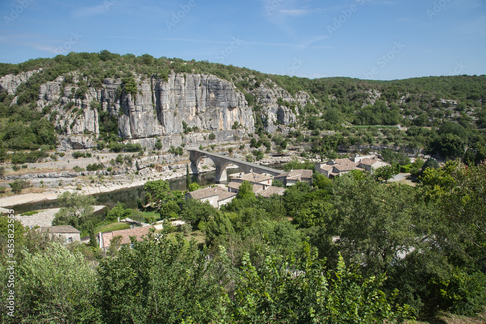 Une partie du village de Balazuc dominant le pont, la rivière Ardèche et les falaises calcaires