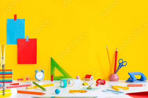 Back to school background. School supplies against a yellow copy space. © mallmo