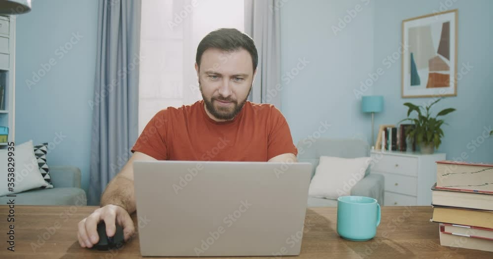 Medium plan of man exposing the computer, starting video chat with colleagues. A smiling employee talking via video link. Concept of remote work from home, freelance, home office Medium plan of man exposing the computer, starting video chat with colleagues. A smiling employee talking via video link. Concept of remote work from home, freelance, home office
