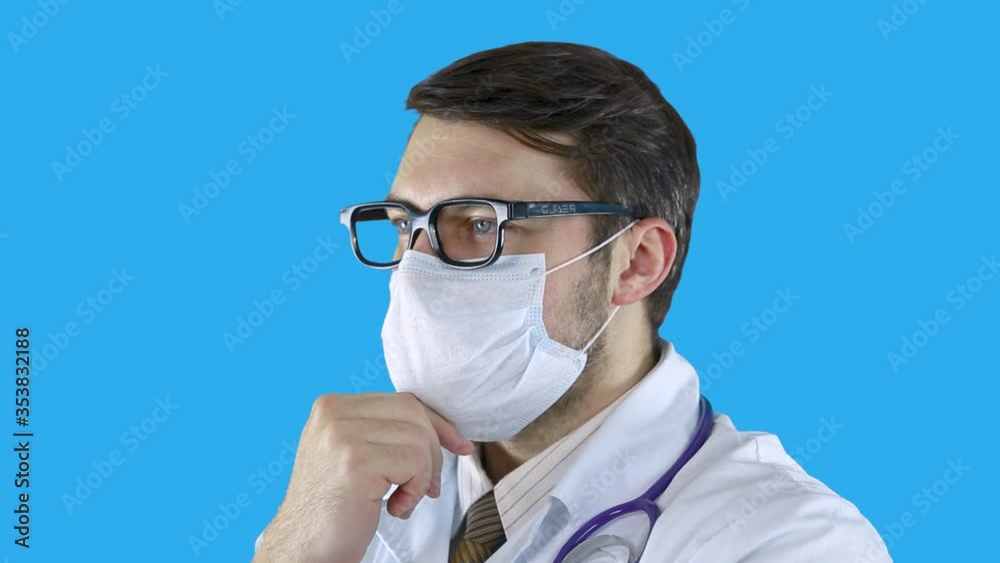 Portrait of a man in a medical coat and mask who holds himself by the chin. Portrait of a man in a medical coat and mask who holds himself by the chin.