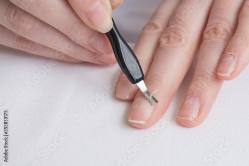 Home manicure. Self-treatment of nails during the pandemic and quarantine. Cuticle removal with a special tool. Close up.