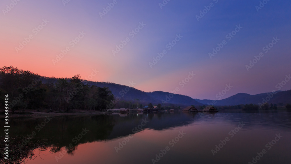 Bamboo houses with mountain on the calm lake backgroud in the morning at Khao wong reservoir, Suphanburi province, Thailand