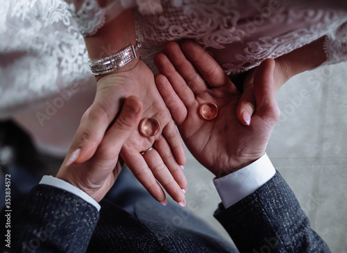 The bride and groom are holding wedding rings