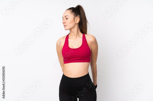 Young sport brunette woman over isolated white background stretching leg © luismolinero
