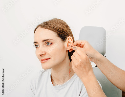 Otolaryngologist making earplugs from an impression of an individual woman ear. Personally molded earplugs