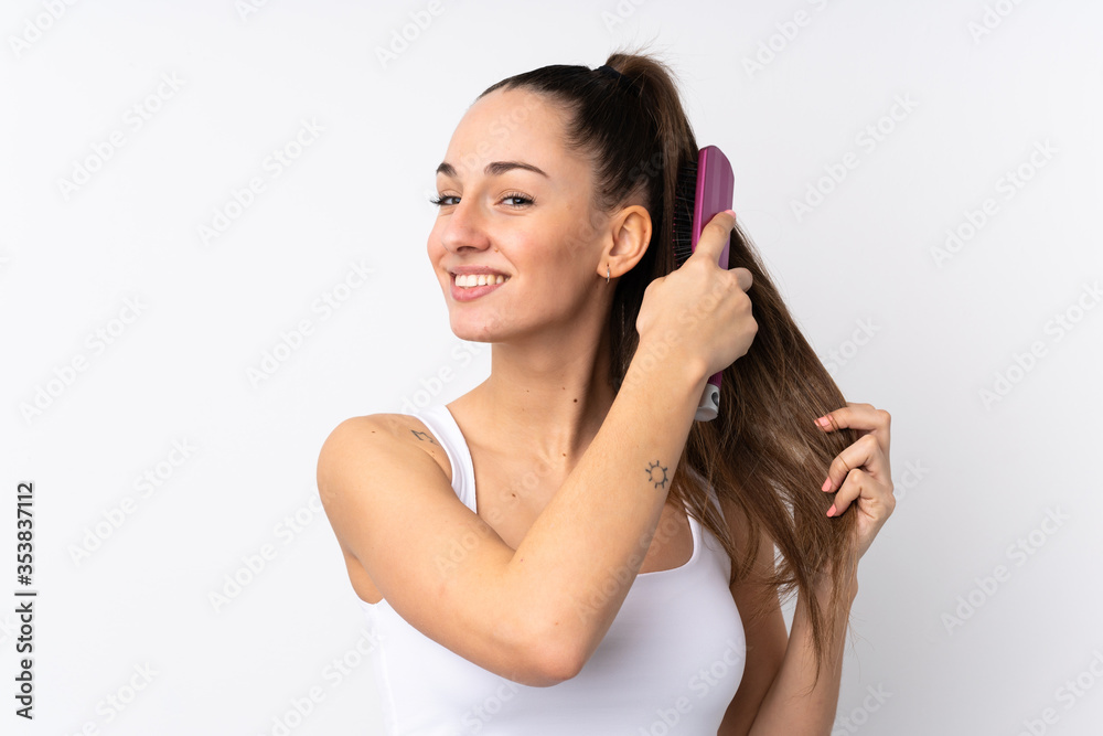 Young brunette woman over isolated white background with hair comb Young brunette woman over isolated white background with hair comb