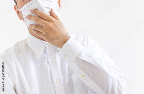 マスクをつけ咳する、ワイシャツを着た男性
