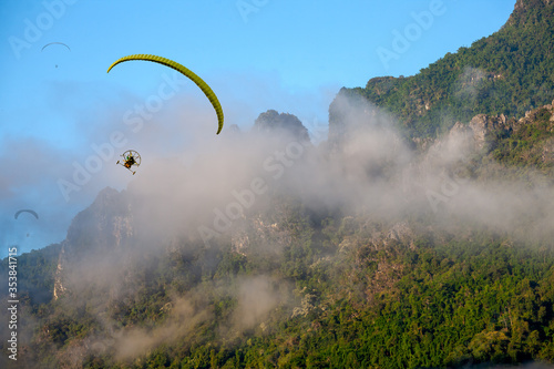 Paramotors flying over a beautiful landscape of mountain and view of Mist and blue sky