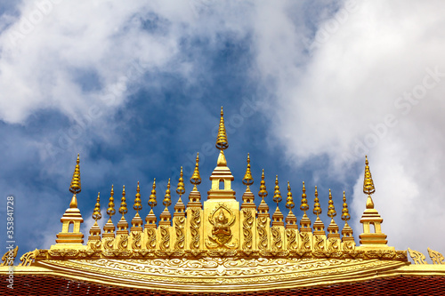 The old roof Buddha Church and vintage gable apex at wat Xieng Thong Luang Prabang on cloudy blue sky