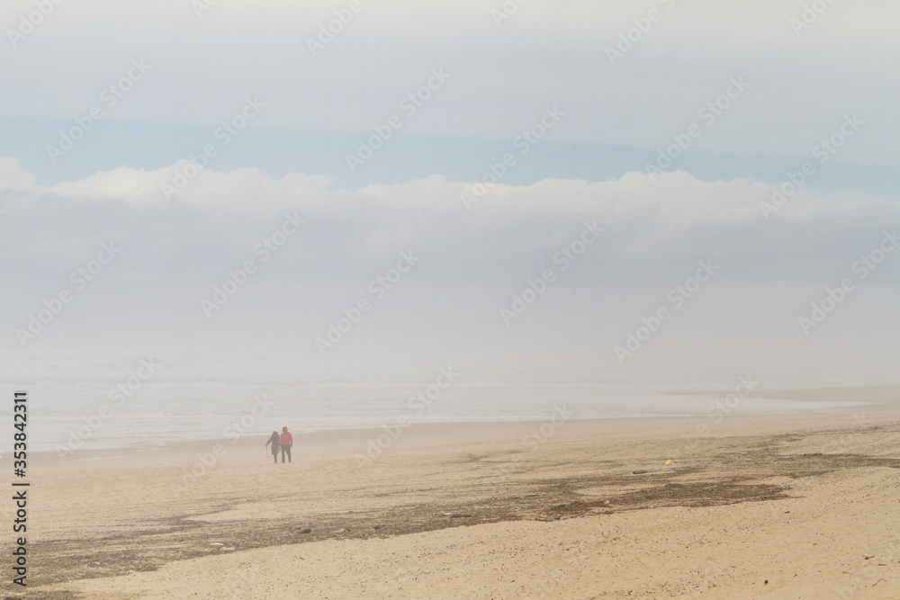 People walking on the beach. Social distancing.