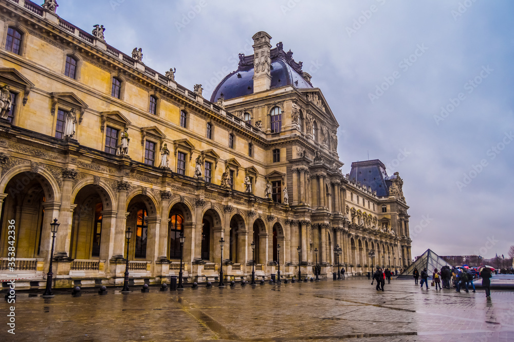 View of famous Louvre Museum and gallery with Louvre Pyramid in Paris France