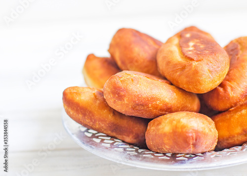 Piroshki - russian baked puff pastry with cabbage fillings. Traditional russian cabbage stuffed baked pastry. lean pies with cabbage. Beautiful homemade cakes with cabbage in metal dishes on white photo