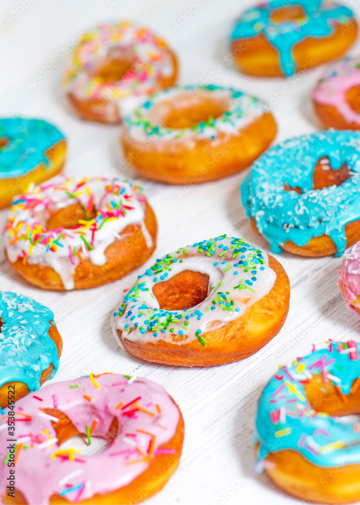 Colorful Donuts turquoise and pink, pattern. Donuts Set on White Background. Doughnuts with multi colored glaze. Doughnuts are traditional sweet pastries. Set of various colorful donuts.
