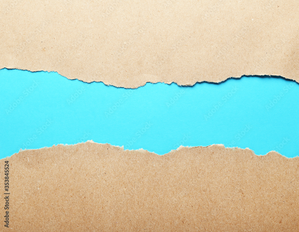 Dark paper with torn edges isolated on a blue background of colored paper inside. Good paper texture