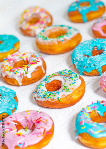 Colorful Donuts turquoise and pink, pattern. Donuts Set on White Background. Doughnuts with multi colored glaze. Doughnuts are traditional sweet pastries. Set of various colorful donuts.