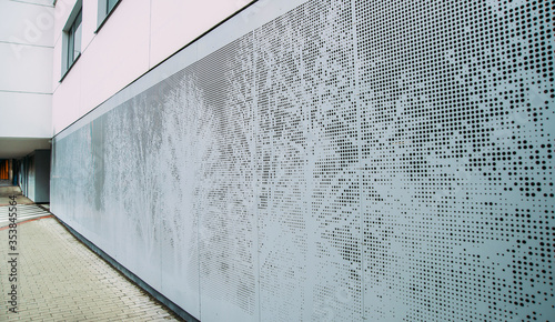 Abstract perforated gray metal panel. Trees pattern